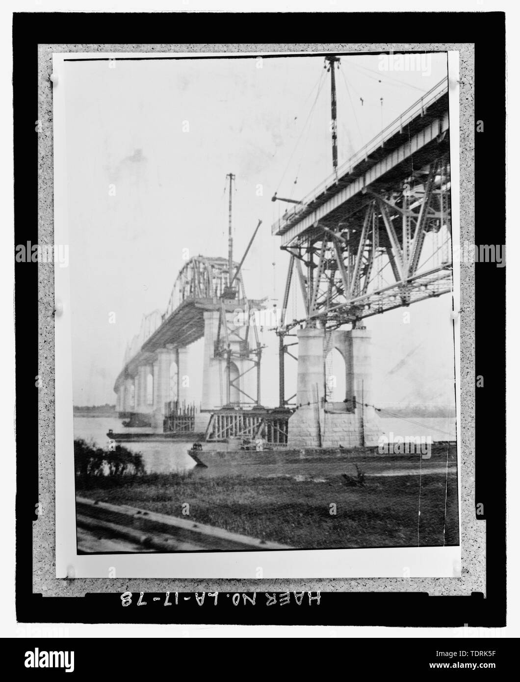 Copie photographique de CIRCA, 1934 Photographie noir et blanc. En vrac dans de grands box situé à au National Museum of American History de la Smithsonian Institution, Centre d'archives, des travaux et de l'industrie Division, Washington, D.C., photographe d'origine inconnue. ; VOIR À PARTIR DE LA RIVE EST À LA BANQUE DU SUD VERS L'OUEST AU PONT EN CONSTRUCTION MONTRANT TERMINÉ PAR TRUSS SPAN ENTRE PIER III ET IV ET LE PONT INACHEVÉ TRUSS SPAN ENTRE PIER IV et V. - Huey P. long pont, enjambant la rivière Mississipi environ à mi-chemin entre neuf et douze mille points en amont et de l'ouest de la Nouvelle Orléans, Banque D'Images