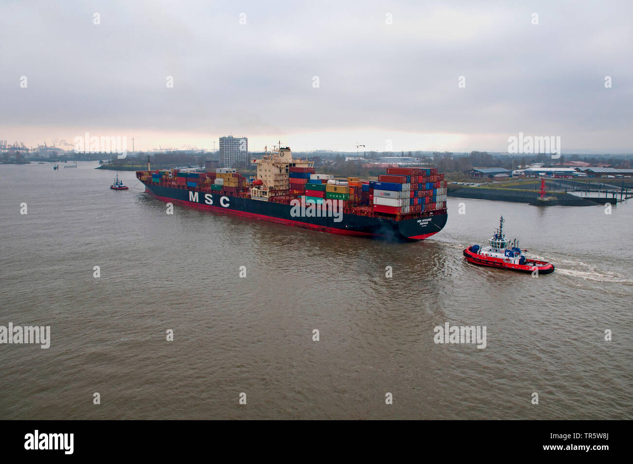 Deux remorqueurs le remorquage du porte-conteneurs MSC grâce à Mykonos l'Elbe et le port de Hambourg, Allemagne, Hambourg Banque D'Images