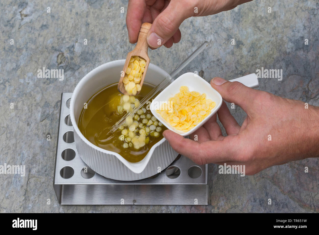 Politique L'onagre (Oenothera biennis), la production de crème glacée, onagre 4 étape : cire d'abeille est ajouté à l'huile dans un pot sur le réchauffement, série photo 4/10, Allemagne Banque D'Images