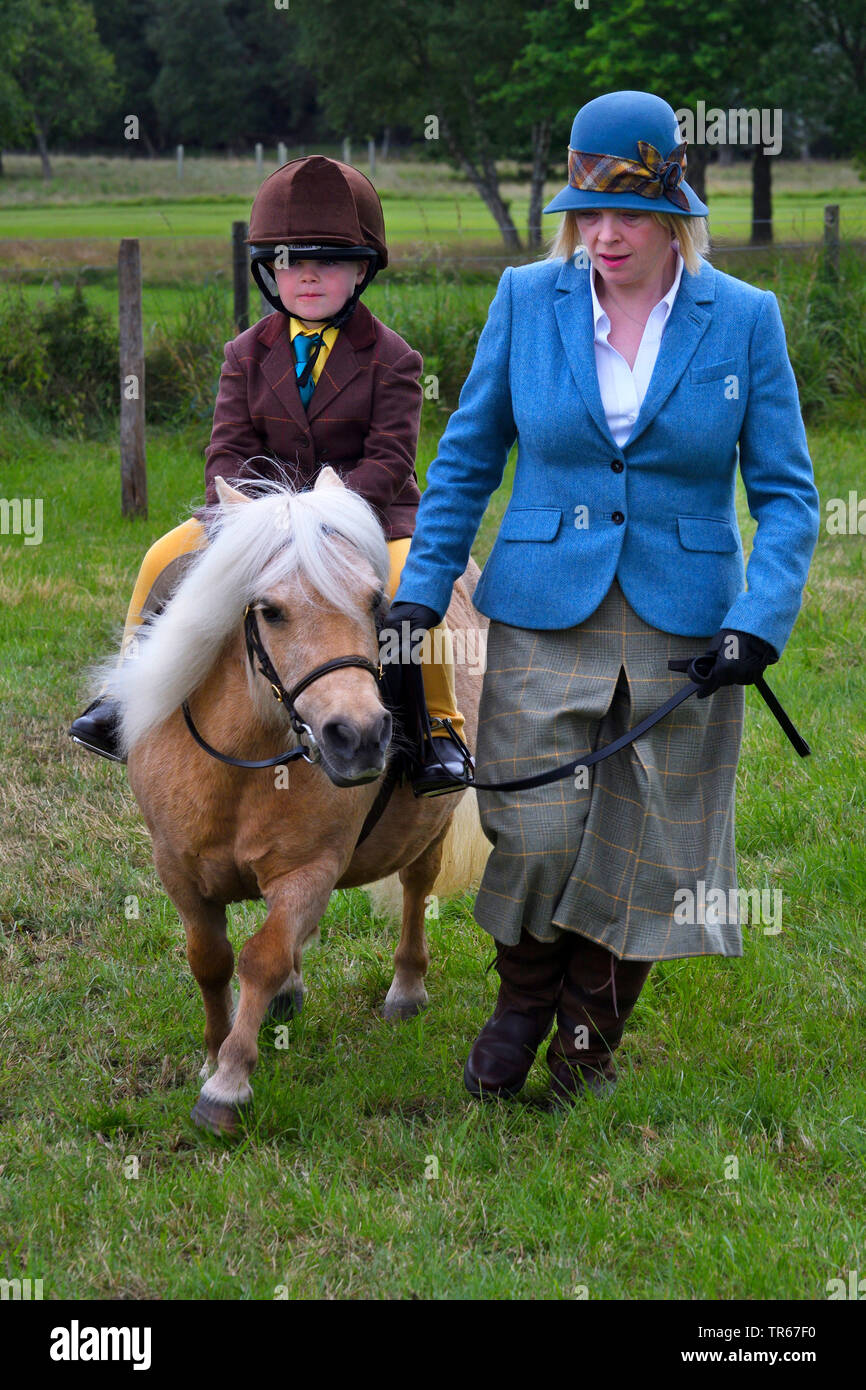 Little Boy riding un poney, mettre sur la laisse par la mère, Royaume-Uni, Ecosse, le Parc National de Cairngorms Banque D'Images