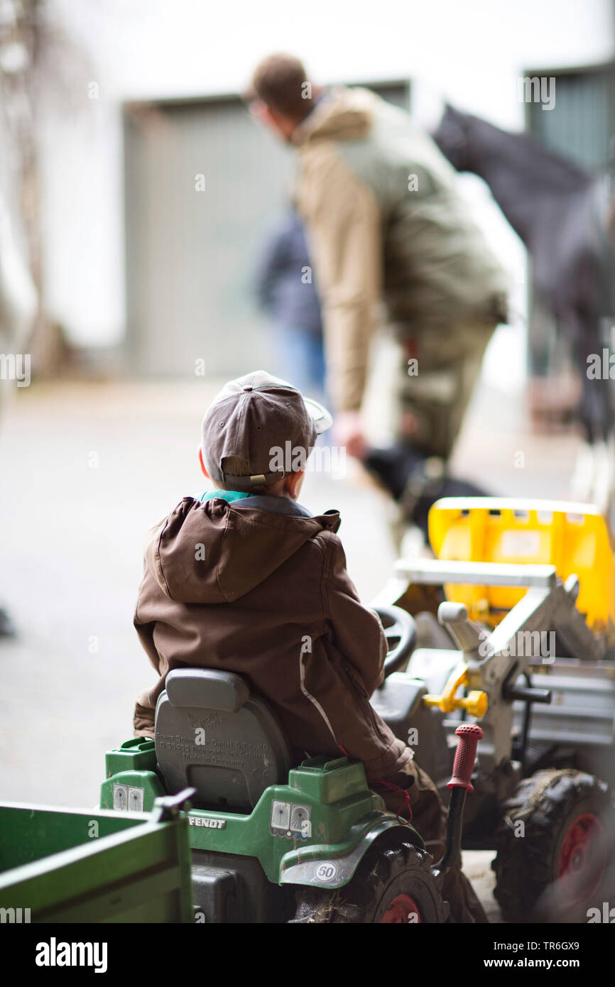Tracteur à pédales sur le garçon, Allemagne Banque D'Images