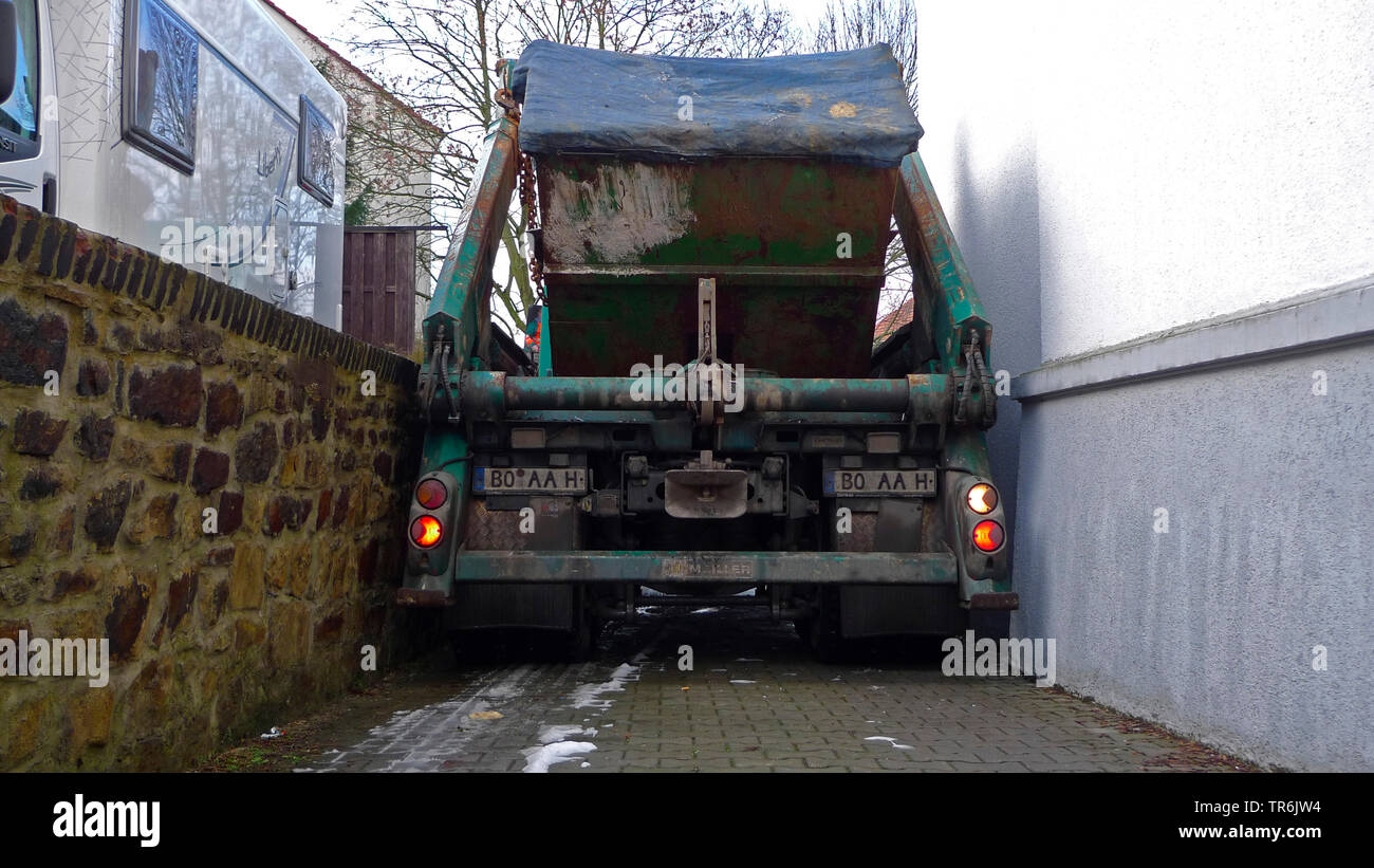 Camion avec le récipient dans une étroite allée de garage Banque D'Images