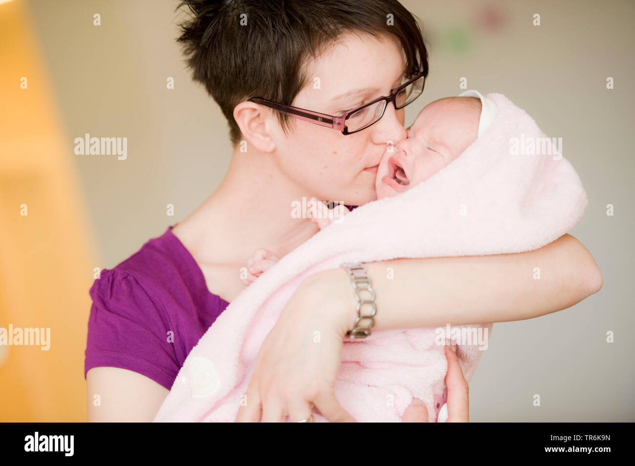 Mère l'embrasse bébé qui pleure Banque D'Images