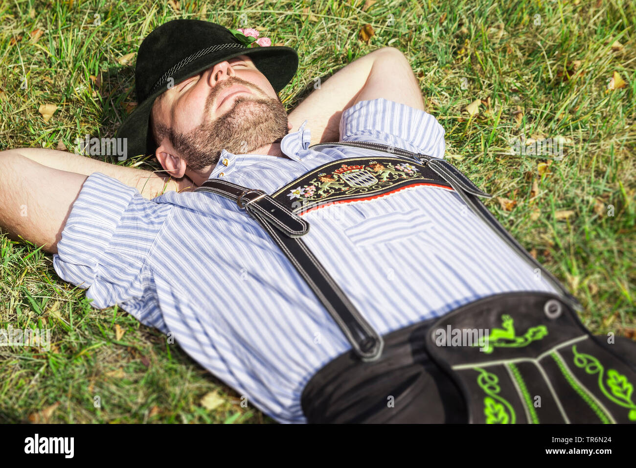 Bavarois traditionnel habillé homme étendu sur un alpage et dormir, l'Allemagne, la Bavière Banque D'Images