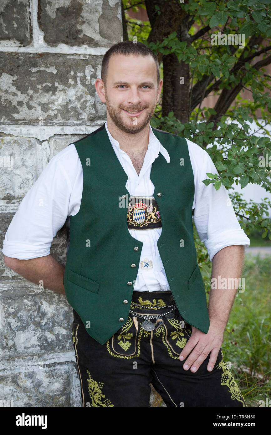 L'homme en costume traditionnel bavarois, appuyé contre un mur de la  maison, de l'Allemagne, la Bavière Photo Stock - Alamy