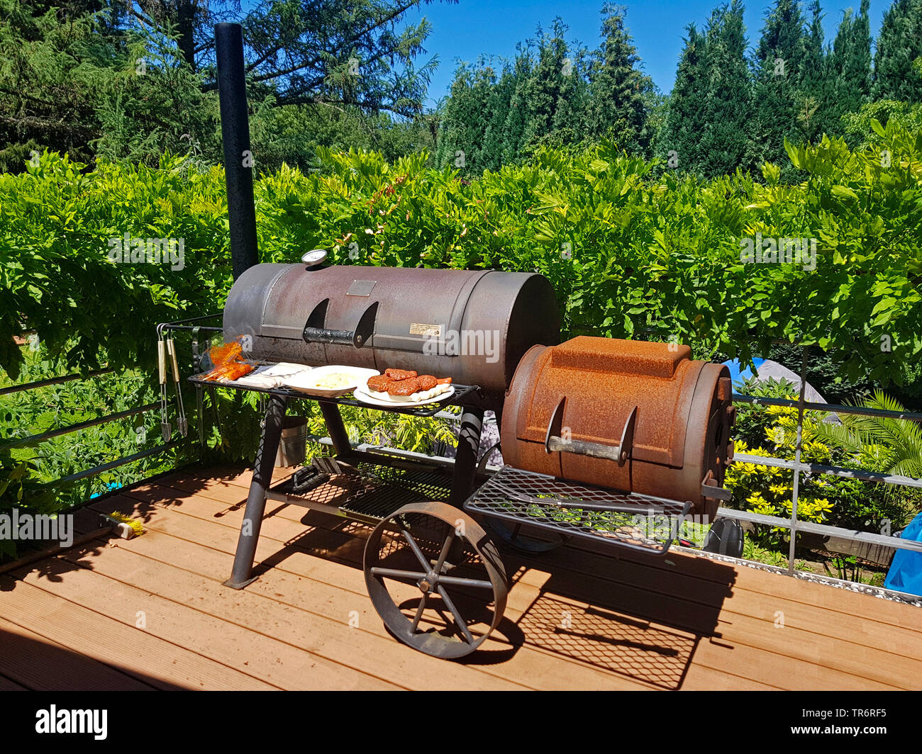 Faire griller de la viande à un Barbecue-Smoker sur une terrasse, Allemagne Banque D'Images