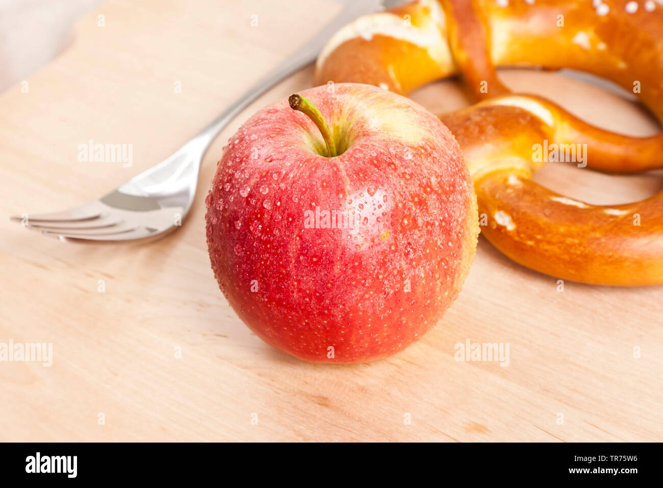 Apple (Malus domestica), apple avec fourchette et bretzel Banque D'Images
