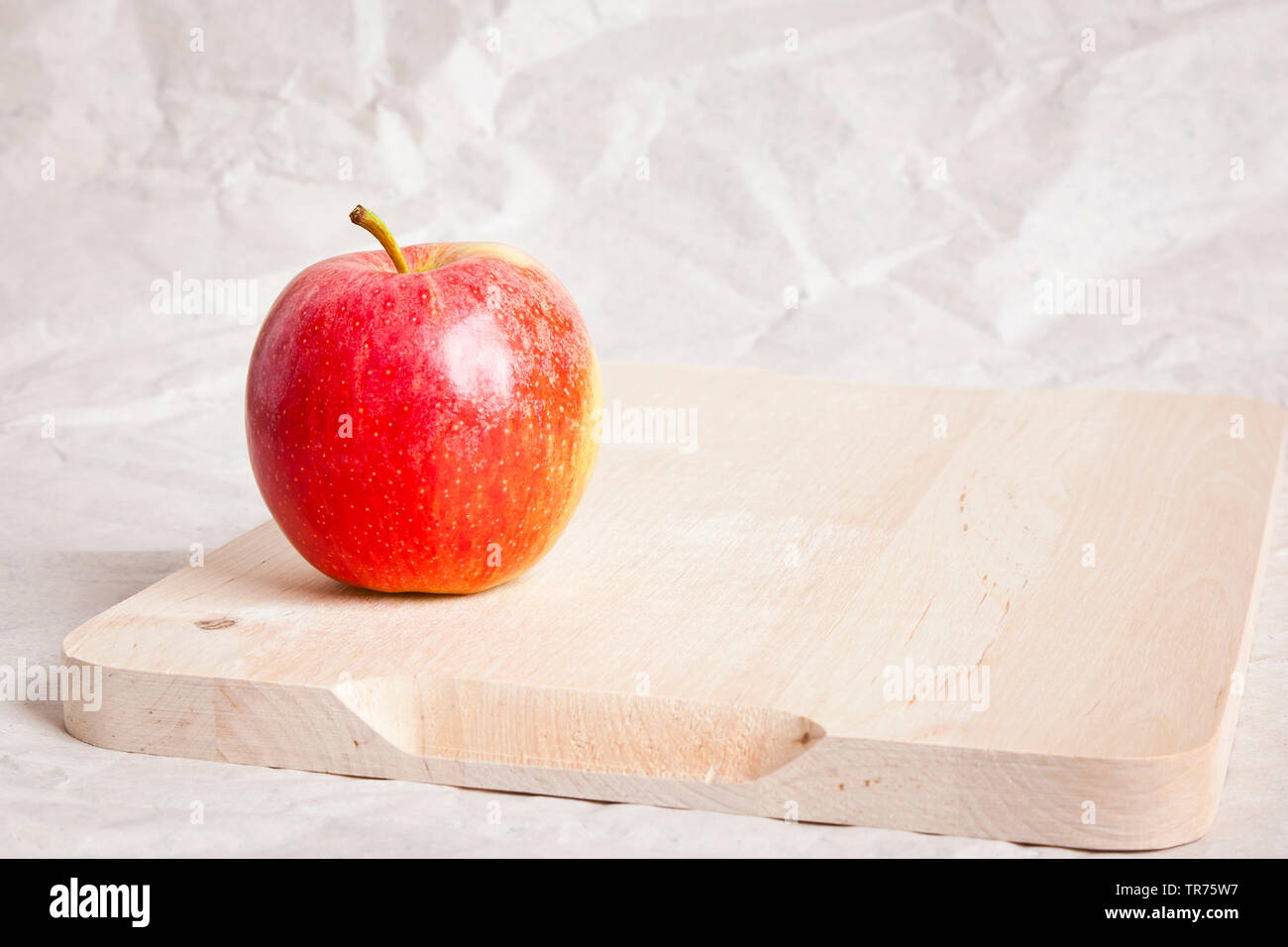 Apple (Malus domestica), pomme rouge sur une plaque woode Banque D'Images