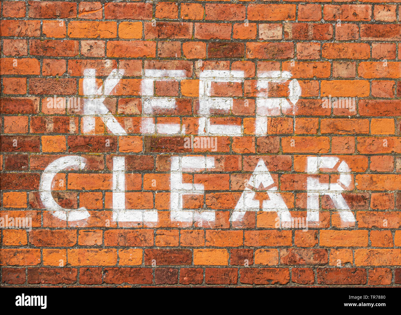 Garder clairement peint sur mur de brique Banque D'Images