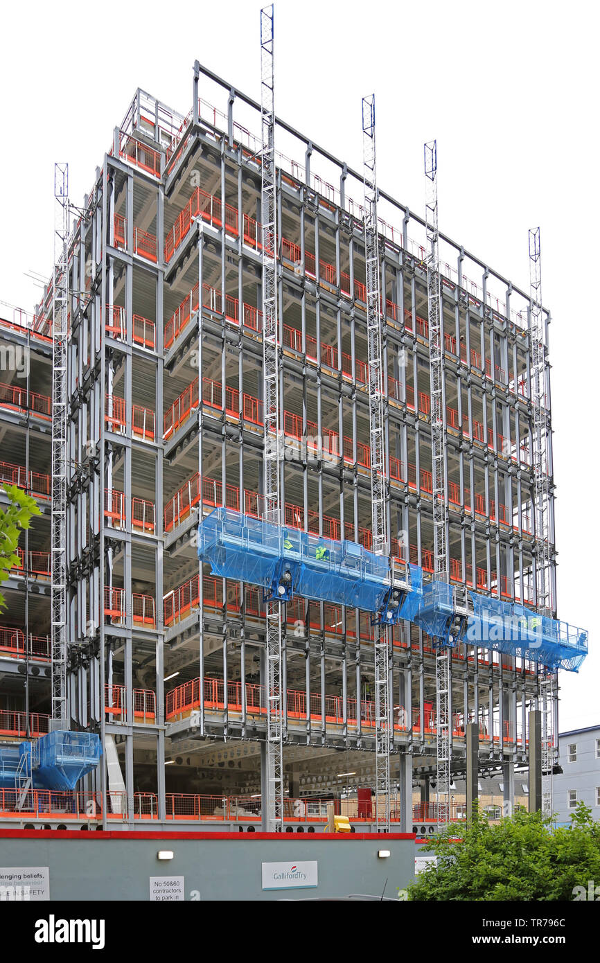 L'escalade du mât électrique plates-formes d'accès à utiliser pour la décoration d'un nouveau bâtiment de bureaux à Cambridge's Station Plazza le développement. UK Banque D'Images