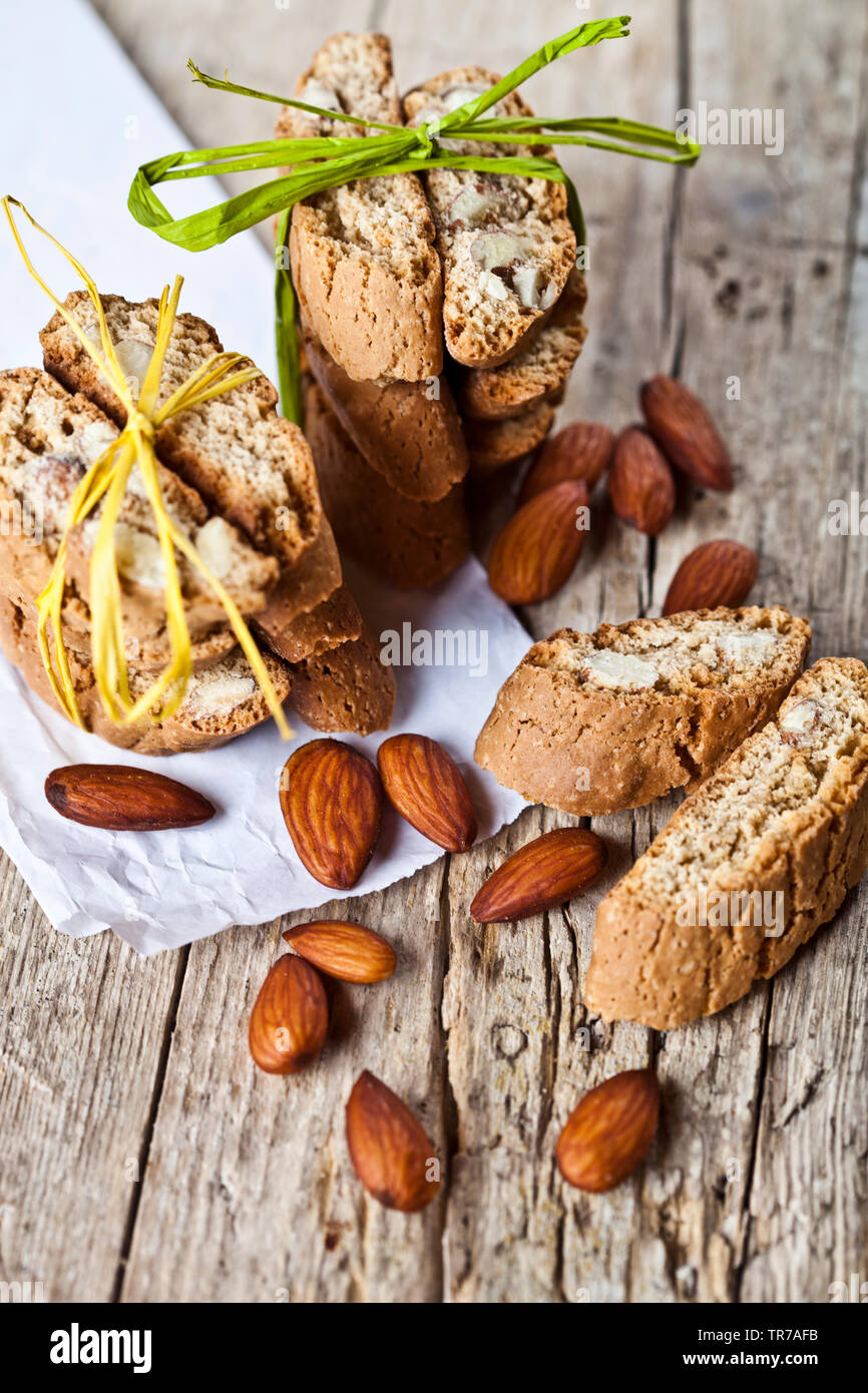 Frais fait maison cookies italiens cantuccini cheminées et graines d'amandes organiques sur du papier blanc sur la table en bois. arrière-plan ructic Gros plan alimentaire sucré. Banque D'Images