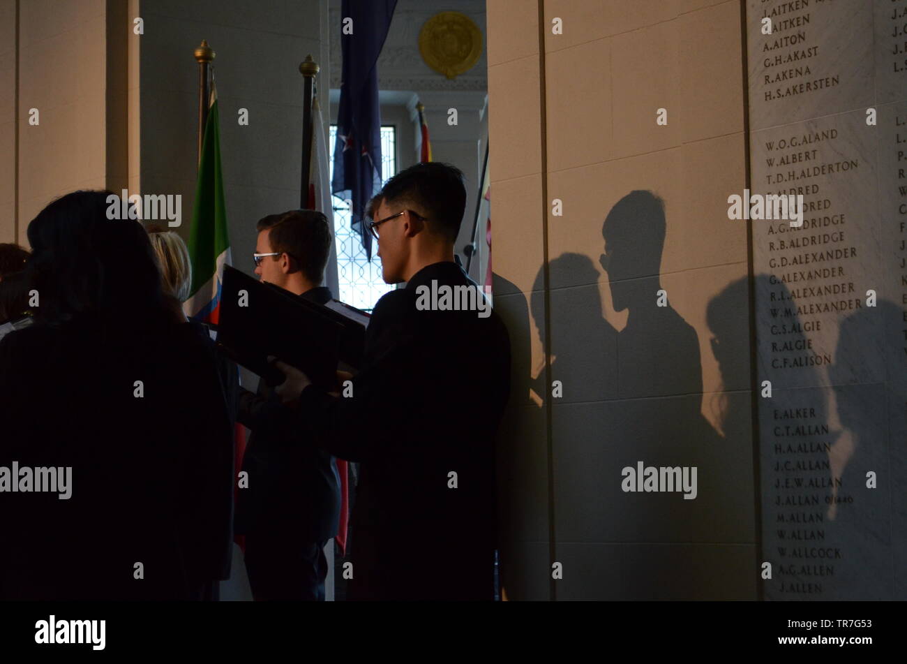 Les jeunes d'Auckland Choristes' ombres sentier derrière le mur dédié aux soldats tombés WW1 dans le sanctuaire à l'Auckland War Memorial Museum Banque D'Images