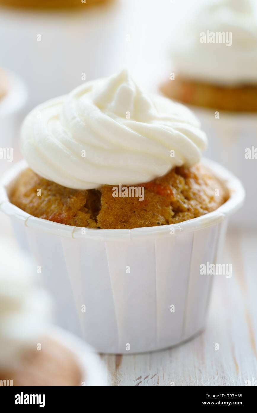 Cupcakes avec glaçage vanille carotte. Table en bois blanc, haute résolution Banque D'Images