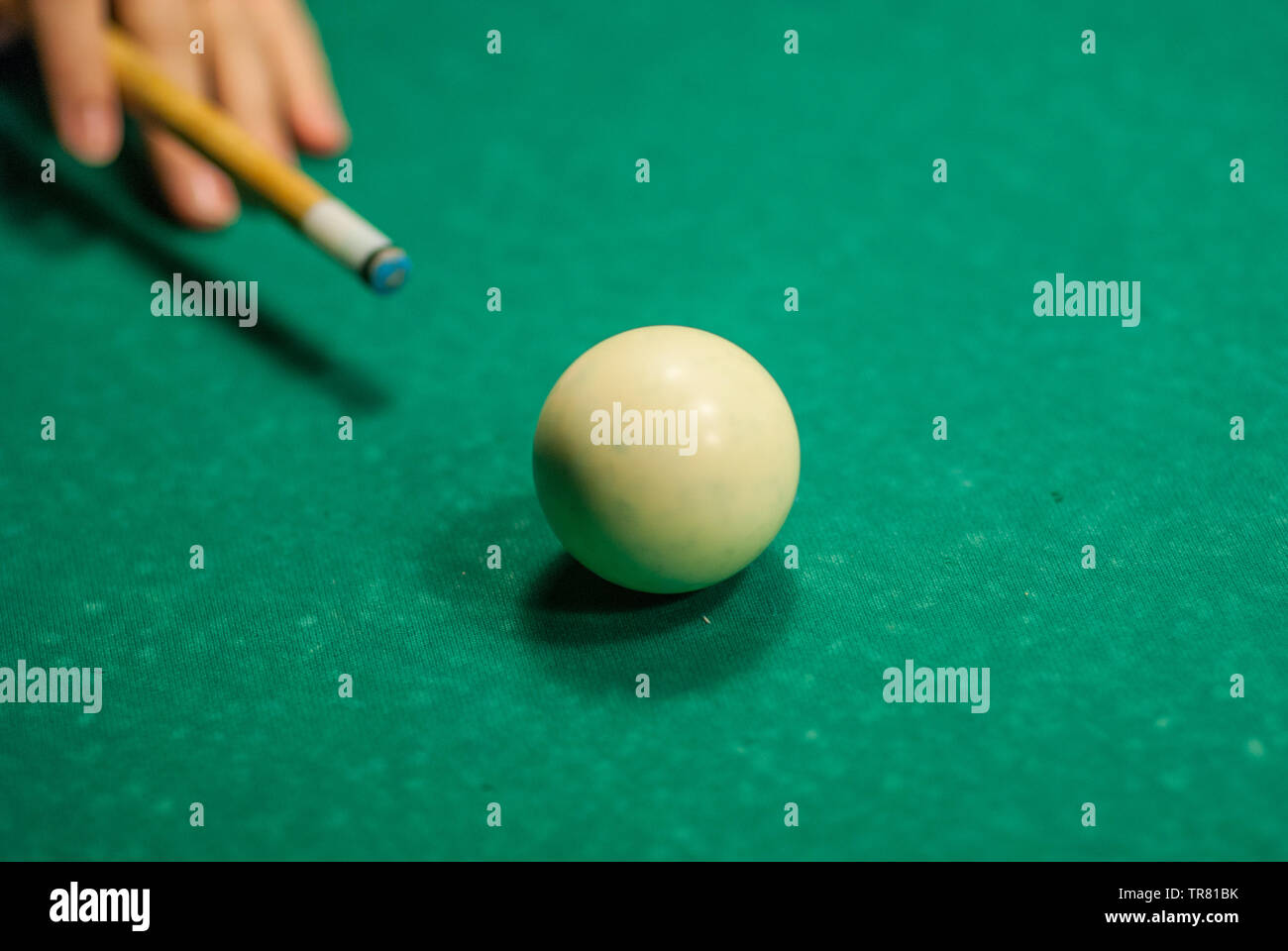 Une main tenant une queue sur le point de frapper une boule blanche, en  jouant au billard Photo Stock - Alamy