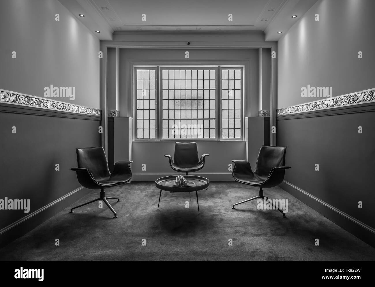 Image en niveaux de gris de chaises dans un hall Banque D'Images