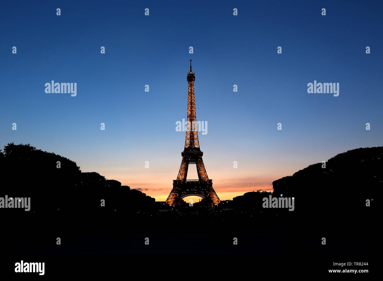 L'emblématique Tour Effiel photographié au coucher du soleil tandis que les lumières scintillent contre le ciel à Paris, France Banque D'Images