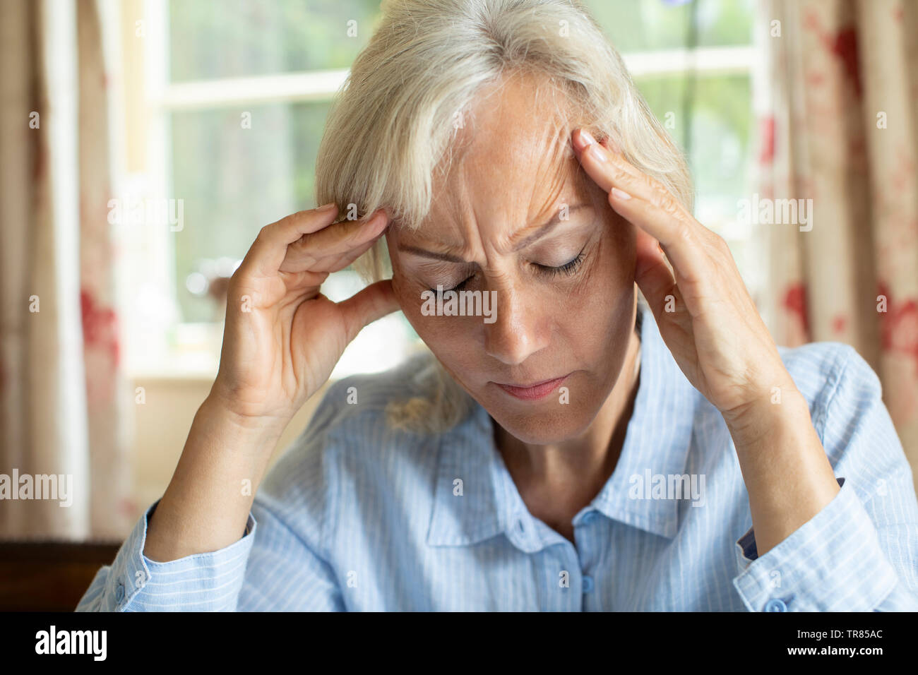 Senior Woman at Home souffrant de migraine maux de tête Banque D'Images