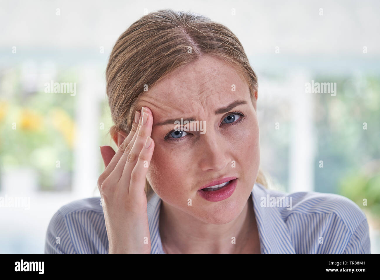 Portrait Of Businesswoman a souligné la souffrance avec maux In Office Banque D'Images