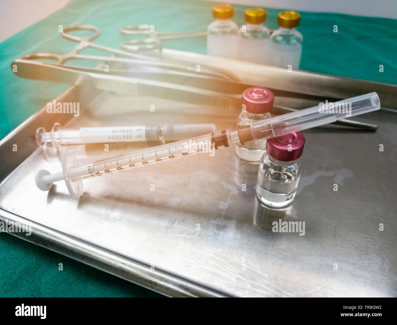 Instruments médicaux matériel / seringue aiguille d'injection de drogues médicales dans le bac en acier chirurgical pour l'infirmière ou du médecin sur le tableau en tissu vert Banque D'Images