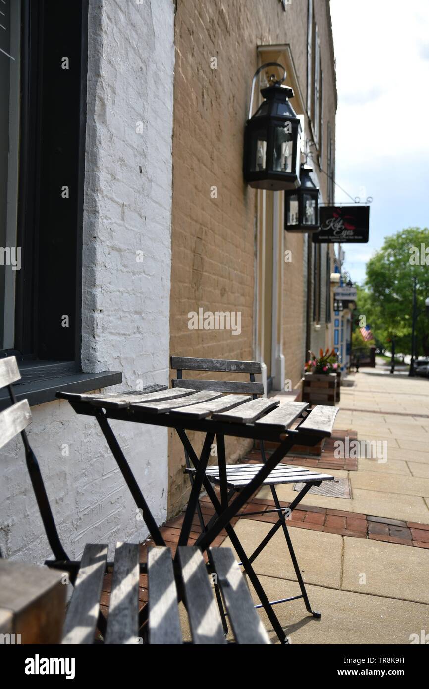 Ensemble Bistro sur un trottoir du centre-ville à l'été au cours de la journée, avec un bâtiment en arrière-plan Banque D'Images