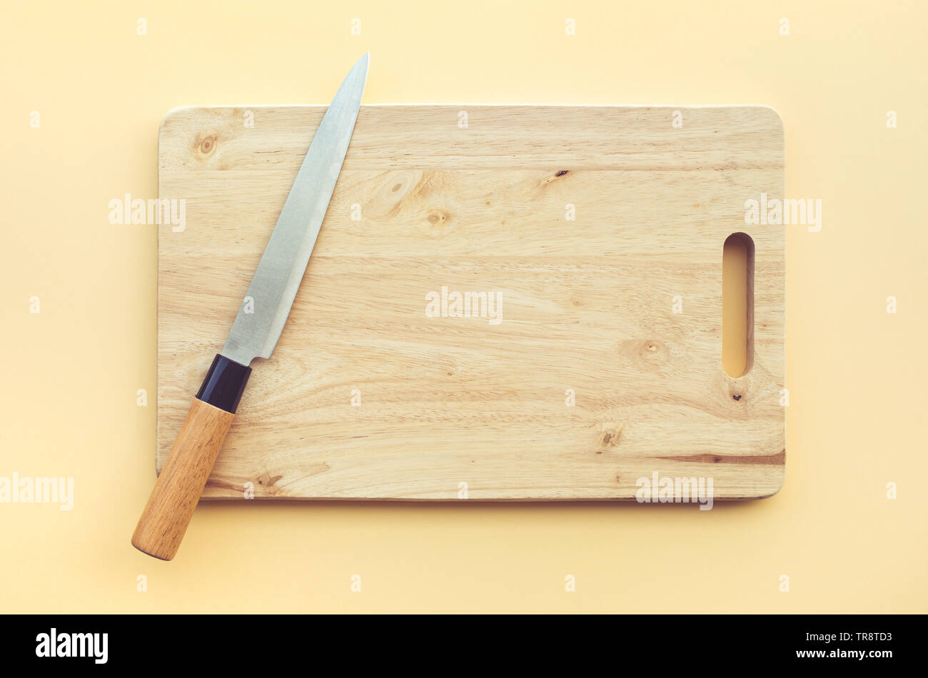 Le couteau à découper en bois sur un fond de couleur pastel Banque D'Images