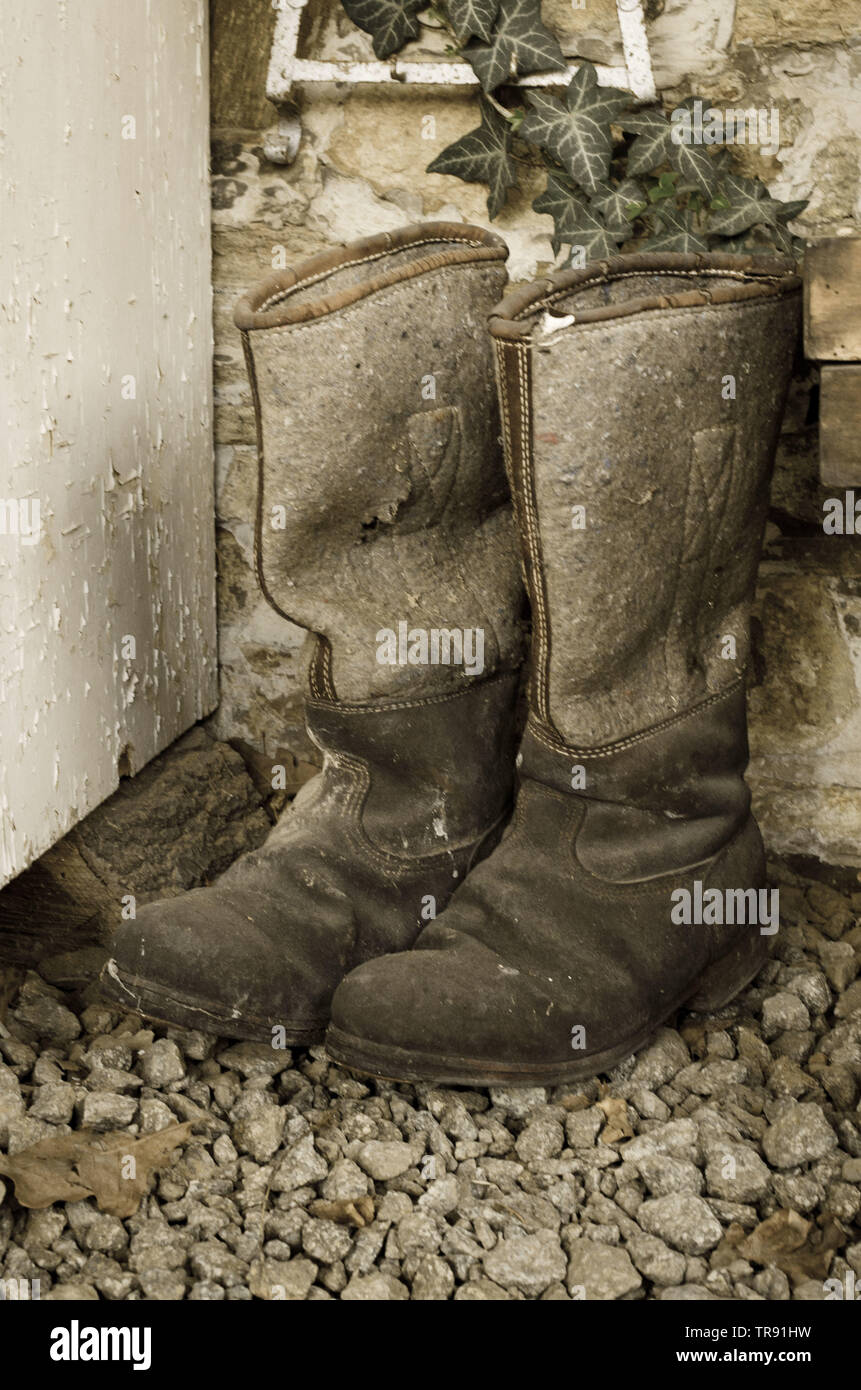 Paire de vieux millésime utilisé l'hiver bottes haute faite de feutre et de cuir. Sepia Banque D'Images
