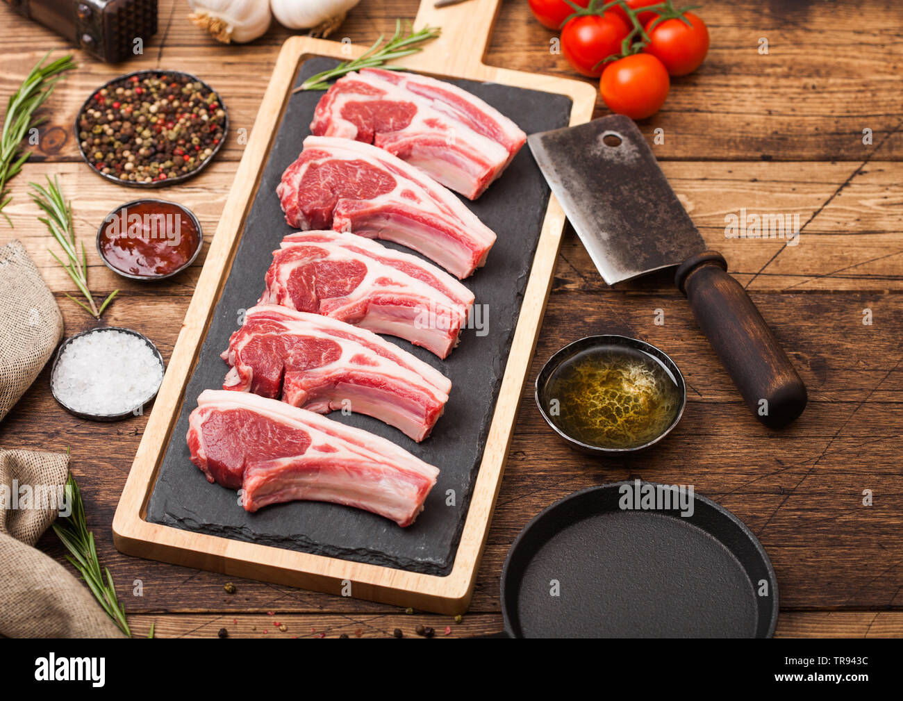 Les Frais D Agneau Roti De Boeuf De Boucherie Sur Planche A Decouper Avec La Viande Hache Et Marteau Vintage Sur Fond De Bois Sel Poivre Et L Huile Avec Les Tomates Un Photo Stock