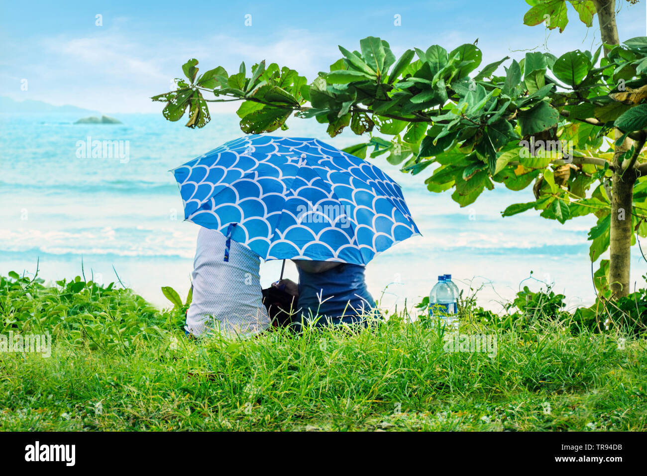 Asian couple enfermé avec un parapluie et en regardant l'océan. Retraités  amoureux sur le bord de la mer. Le Sri Lanka Photo Stock - Alamy