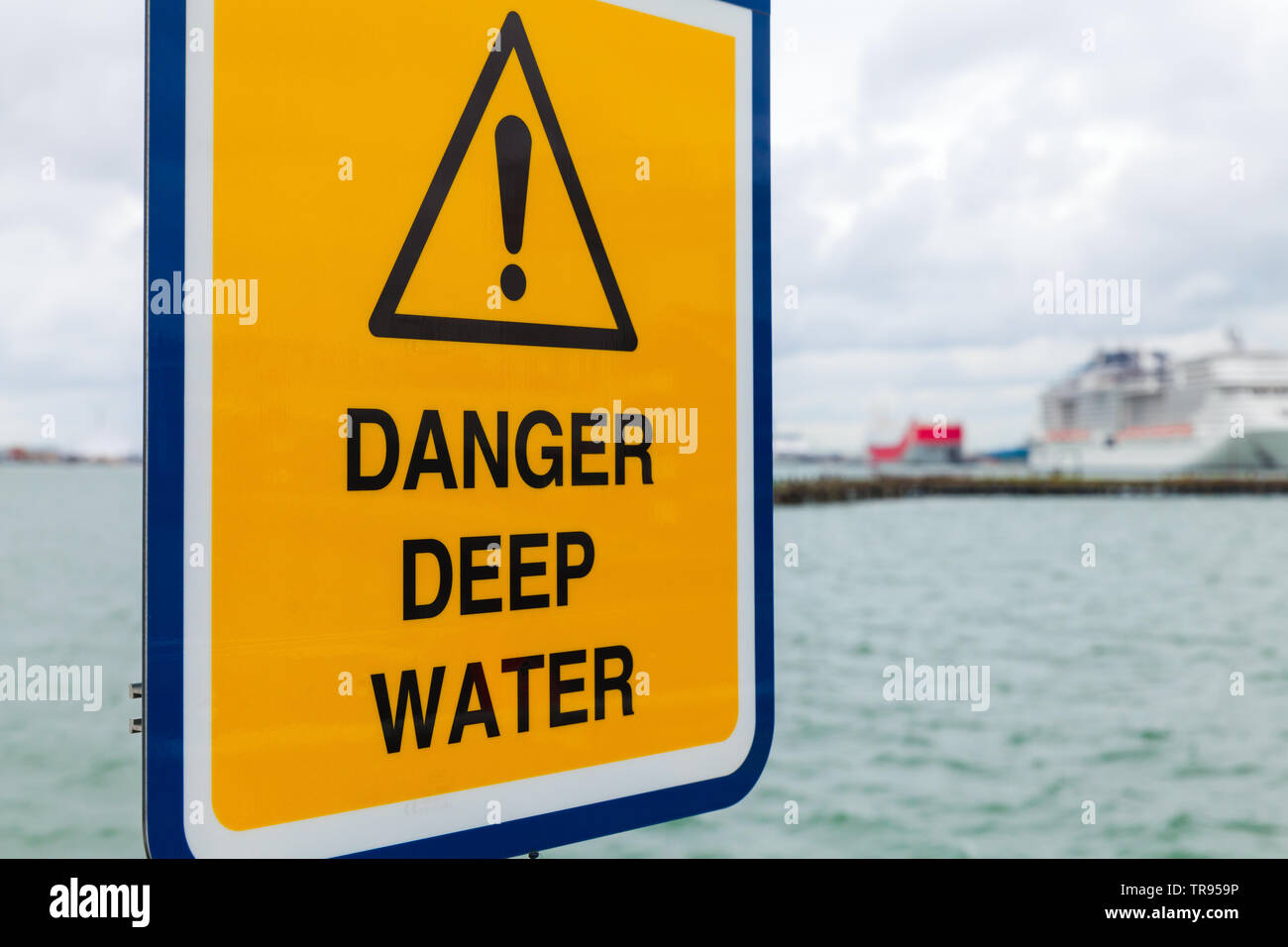 Danger l'eau profonde. Panneau d'avertissement jaune monté dans le port de Southampton Banque D'Images