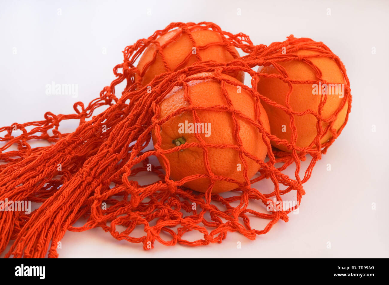 Chaîne à la main sac avec trois oranges Banque D'Images