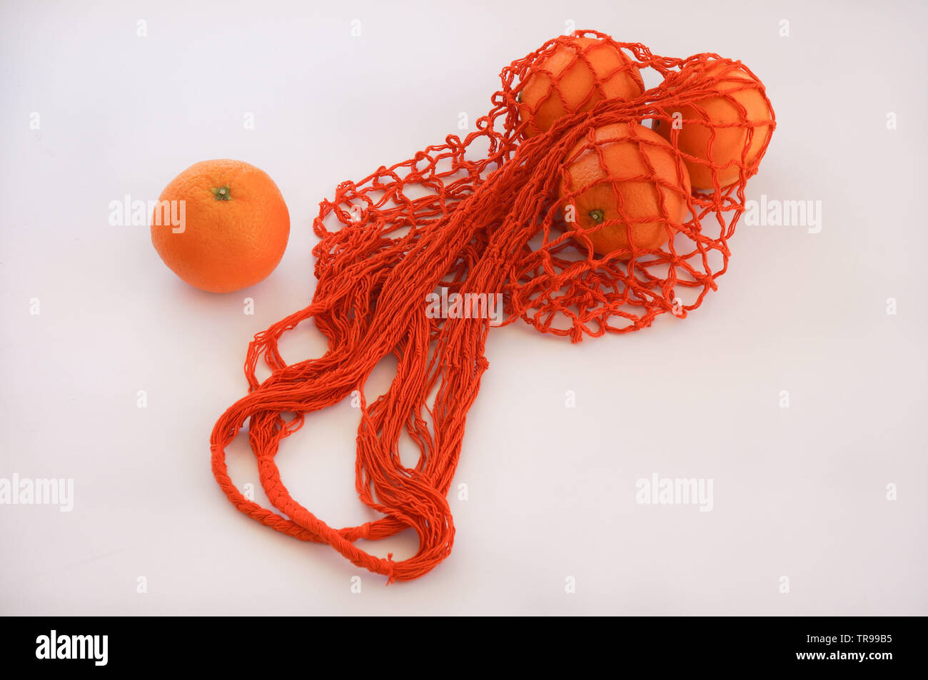 Chaîne à la main sac avec trois oranges Banque D'Images