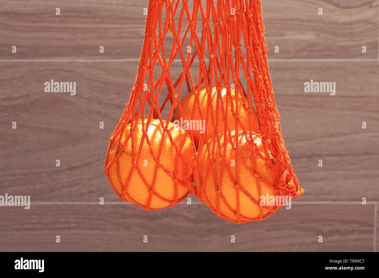 Chaîne à la main sac avec trois oranges Banque D'Images