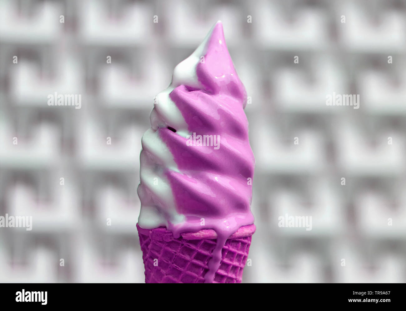 Blanc de fusion et de couleur rose vif cornet de crème glacée molle avec mur de béton moderne flou en arrière-plan Banque D'Images