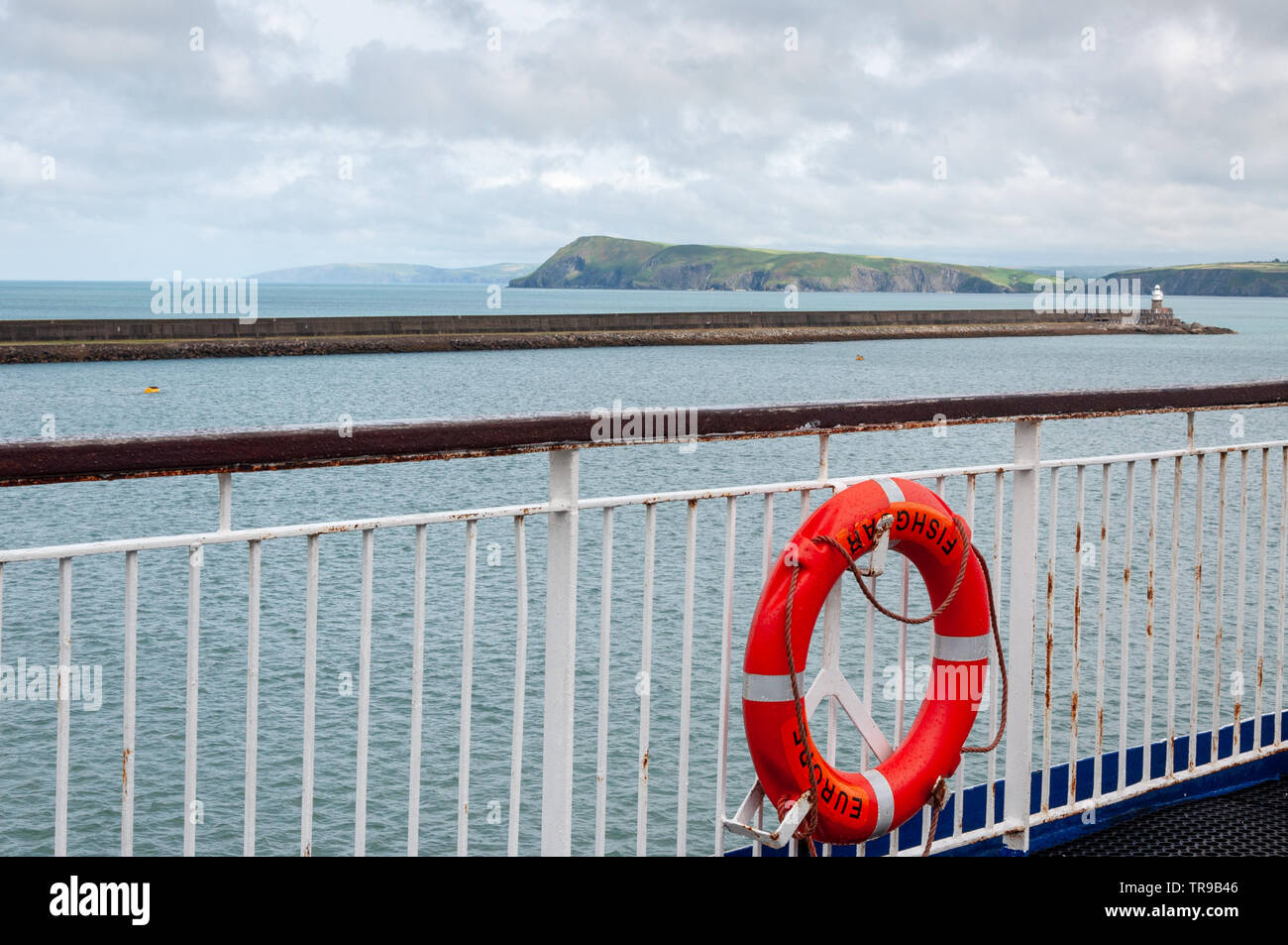 Vue sur le pont du ferry de Stena Line jusqu'au mur du port de Fishguard et au phare Fishguard ou Abergwaun, Pembrokeshire, pays de Galles, Royaume-Uni Banque D'Images