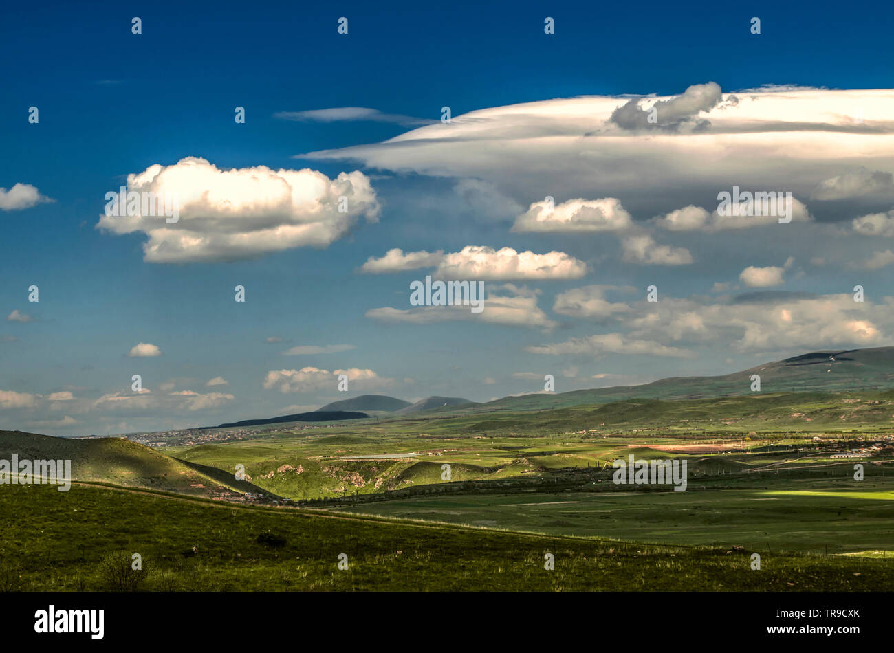 Dans le ciel bleu de printemps du froid du vent qui souffle depuis les montagnes de la gamme nuage turbulent Geghama se déplace avec les Cumulus couvrant la villa Banque D'Images