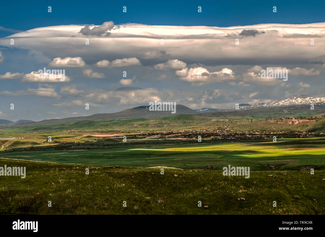 Le vent froid venant de la chaîne de montagnes Geghama sur le ciel bleu de printemps ont formé un nuage Cumulus turbulents avec déplacement dans les villages et des va Banque D'Images