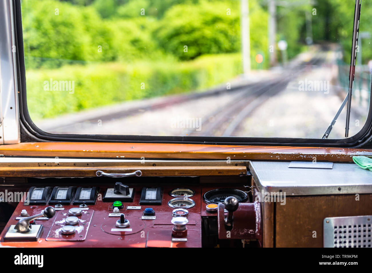 Une vue de la fenêtre d'un train de chemin de fer, un tableau de bord visible, les voies, les arbres et un ciel bleu avec des nuages blancs. Banque D'Images