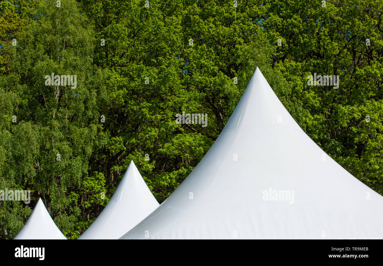 Les toits pointus de tentes parti en face d'une forêt. Banque D'Images