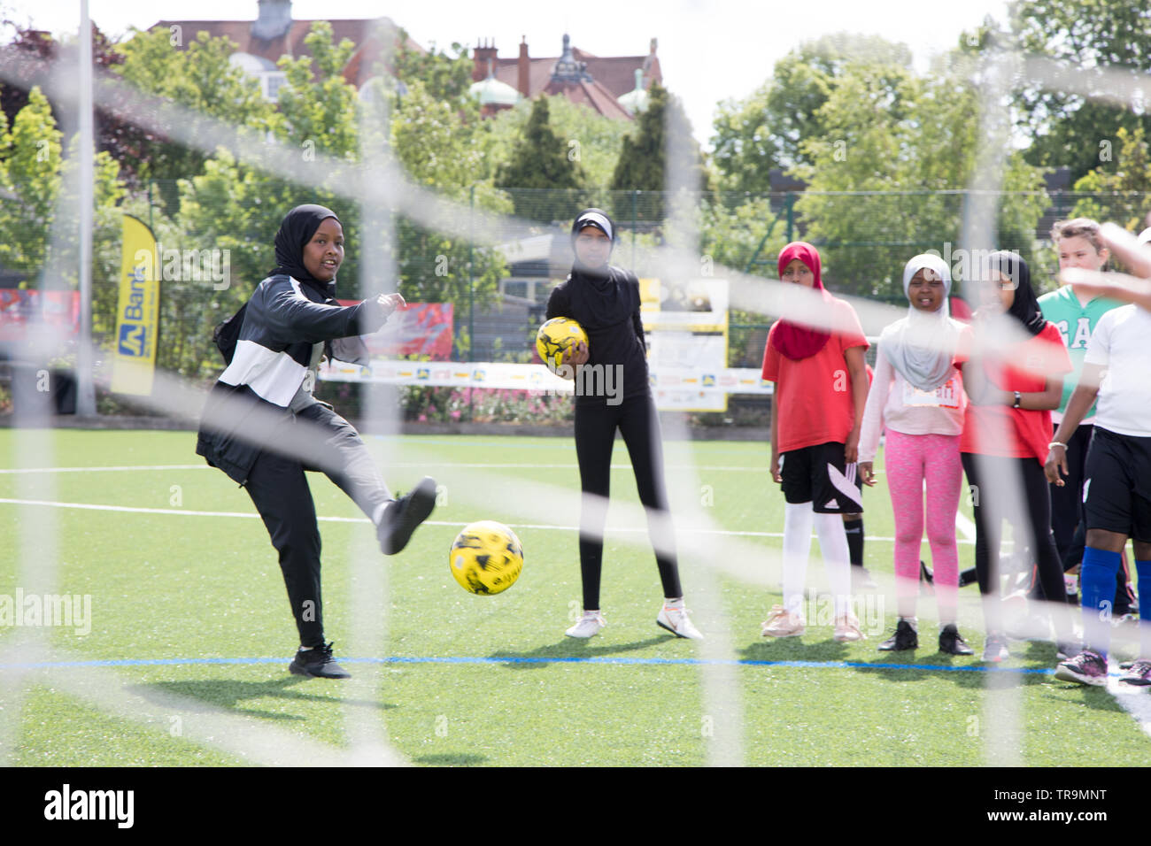 Avec une jeune musulmane tire un foulard au football but pendant une session de formation Banque D'Images