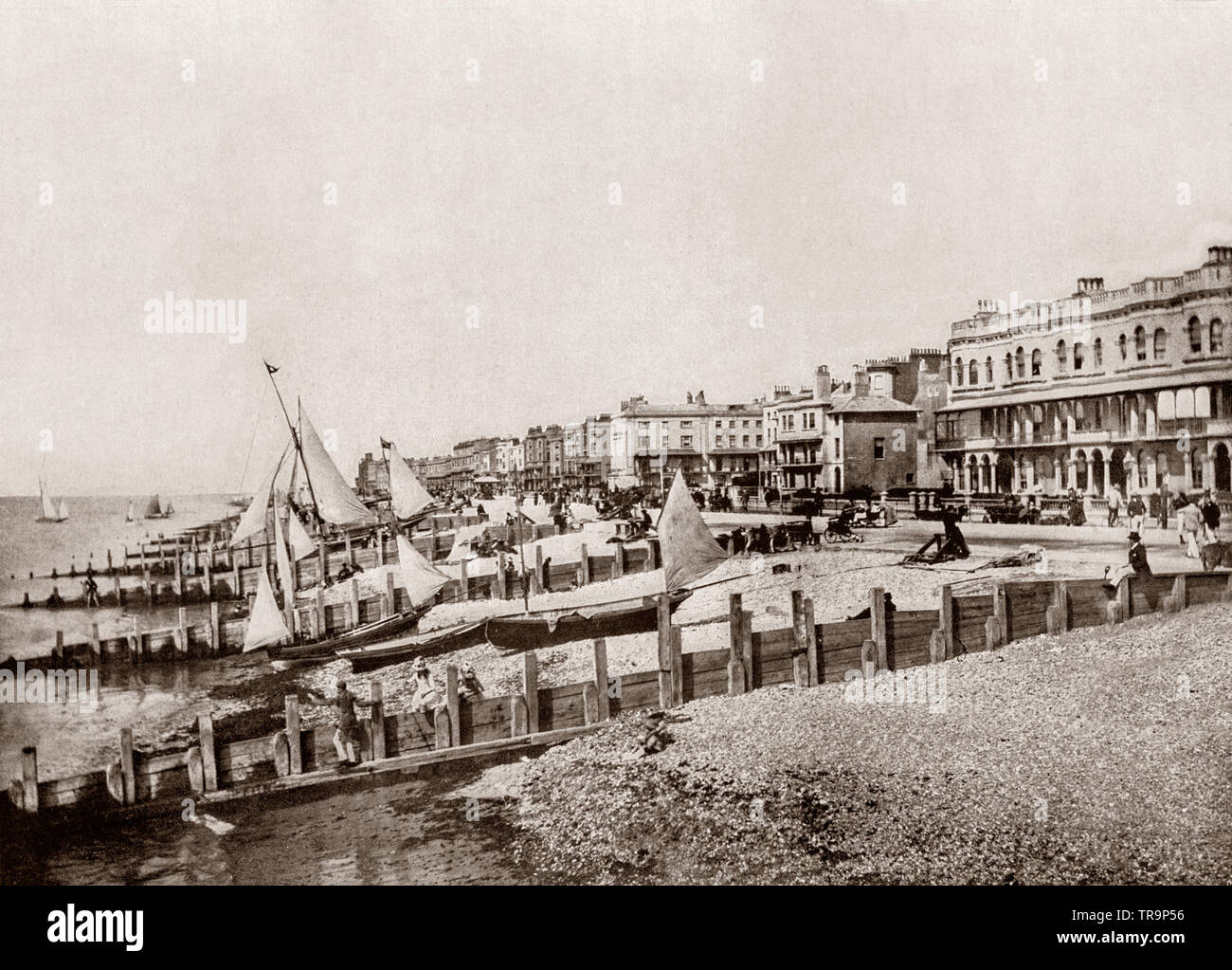 Un 19e siècle voir des défenses et des yachts sur la mer sur la plage de Worthing, une grande ville balnéaire dans le West Sussex, Angleterre. Worthing était resté un hameau agricole et de pêche pendant des siècles jusqu'à l'arrivée de visiteurs fortunés dans les années 1750. La ville a élargi au 19e siècle, mais était aussi un fief de passeurs, le site d'émeutes par l'Armée de squelette dans les années 1880 et a writer's Paradise - Oscar Wilde a écrit l'importance d'être constant au cours de sa deuxième visite. Banque D'Images
