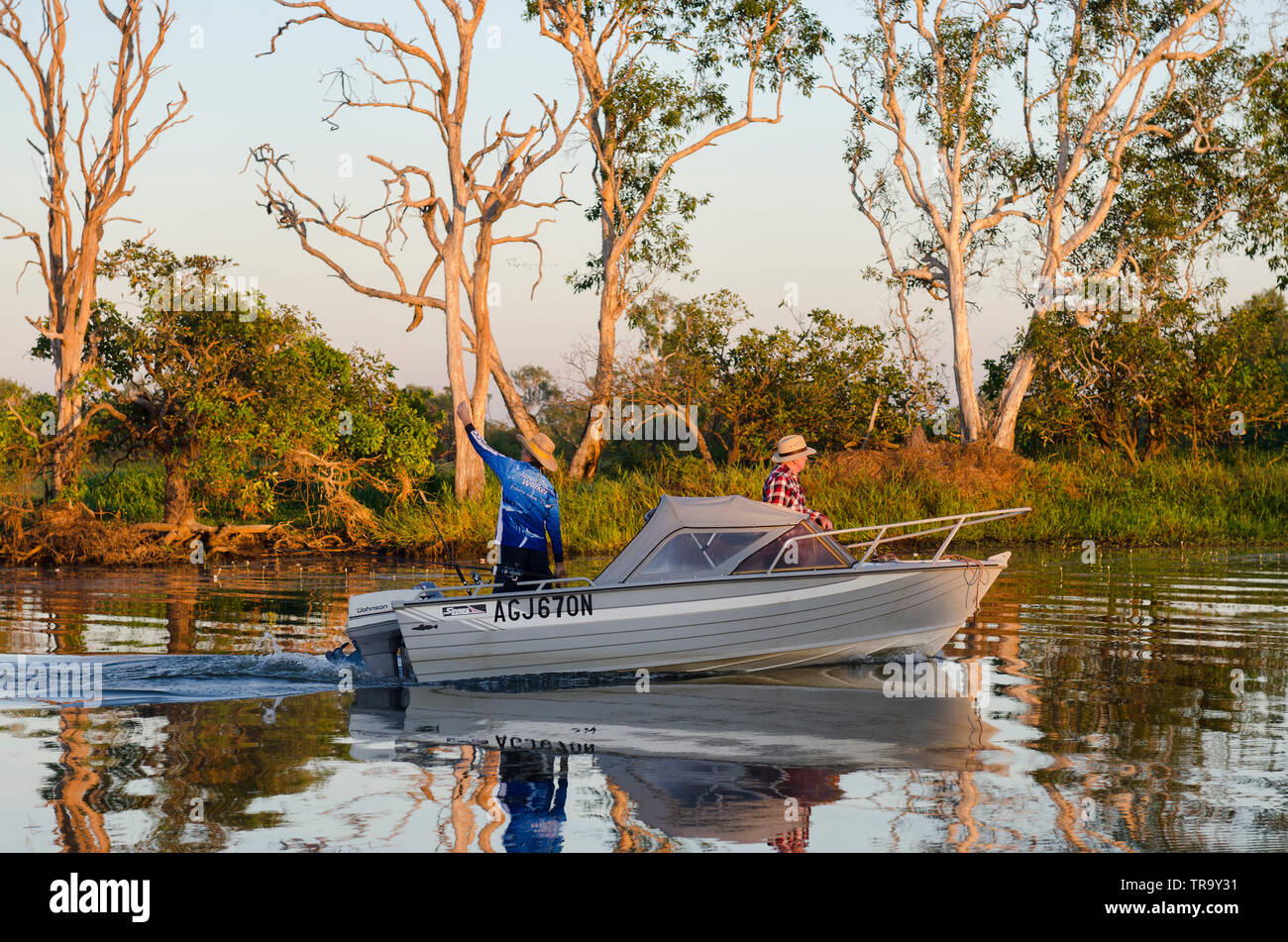 Deux hommes dans un bateau, pêchant au premier feu pour Barramundi, sur le billabong Yellow Water, Kakadu, territoire du Nord, Australie Banque D'Images