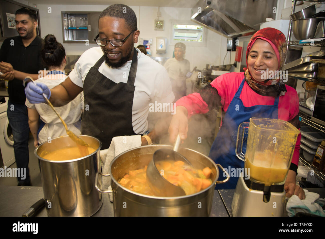 Bénévoles à une cuisine communautaire préparer un repas pour les diners dans le besoin. Banque D'Images