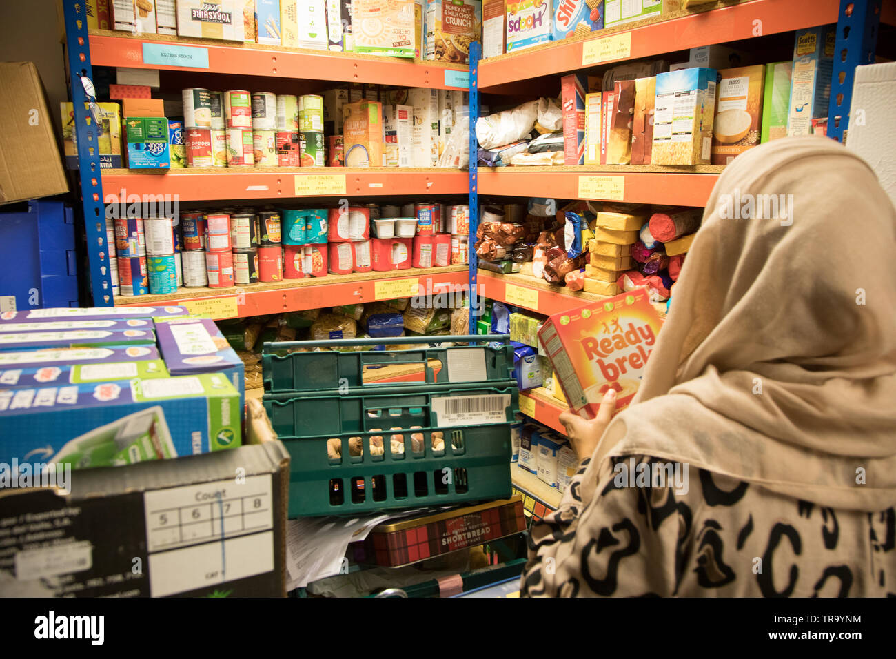Une femme musulmane avec un foulard Sacs Sacs à un comptoir alimentaire Banque D'Images