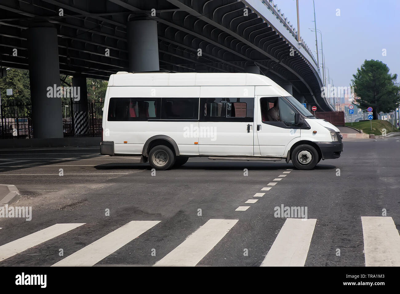 Minibus blanc va sur la ville street Banque D'Images