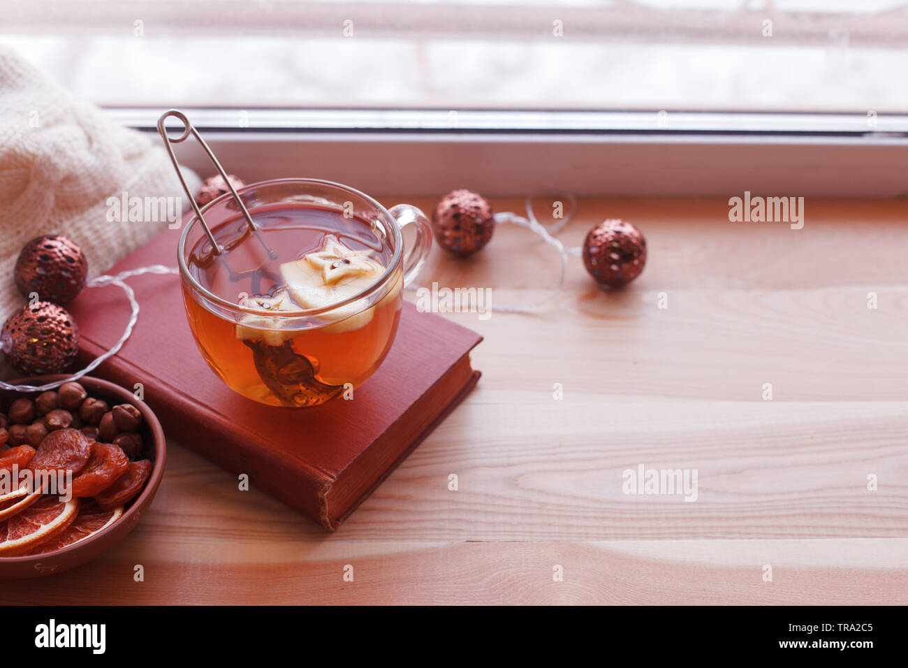 Concept d'automne chaudes et confortables. Livre, tasse de thé sur appui de fenêtre dans la chambre. La lecture et de détente par temps froid à la maison. Le silence paisible scène familiale. Mono Banque D'Images