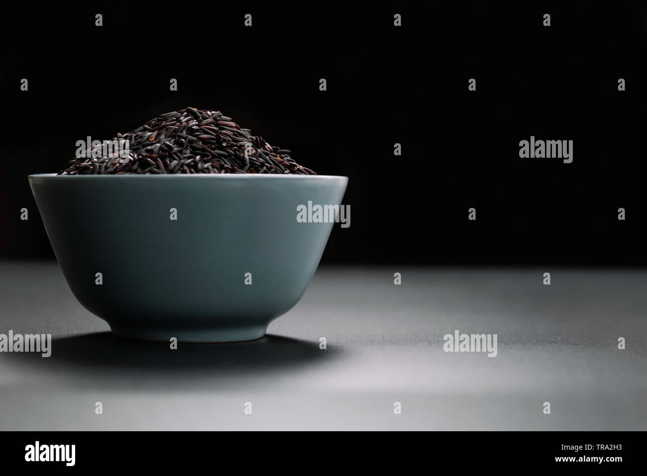 Bol de riz noir au jasmin sur fond noir Banque D'Images