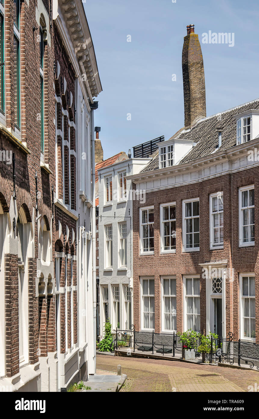 Middelburg, Pays-Bas, Mai 30, 2019 : rue de la vieille ville en tournant autour d'un coin, avec deux étages recouverts de tuiles du toit des maisons et un grand chi Banque D'Images