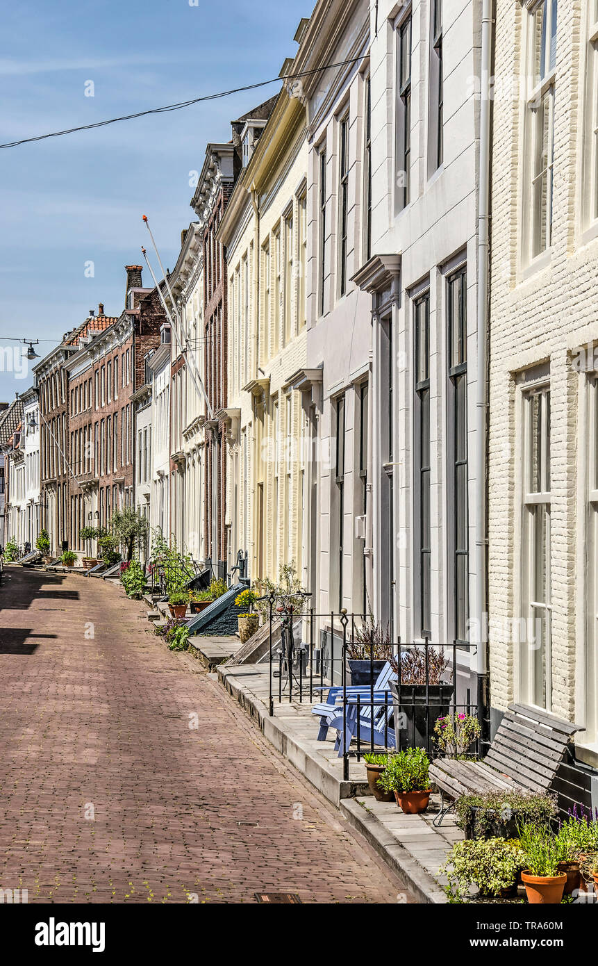 Middelburg, Pays-Bas, Mai 30, 2019 : ligne de façades de maisons avec des façades de brique et de zones semi-privé avec des plantes, des clôtures et des bancs Banque D'Images
