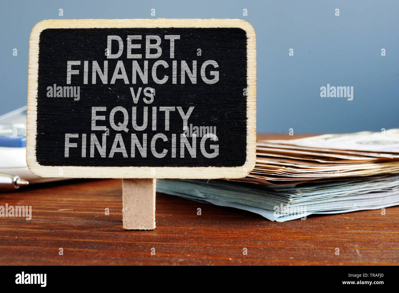 Le financement de la dette vs Financement par capitaux propres. Calculatrice et espèces. Banque D'Images