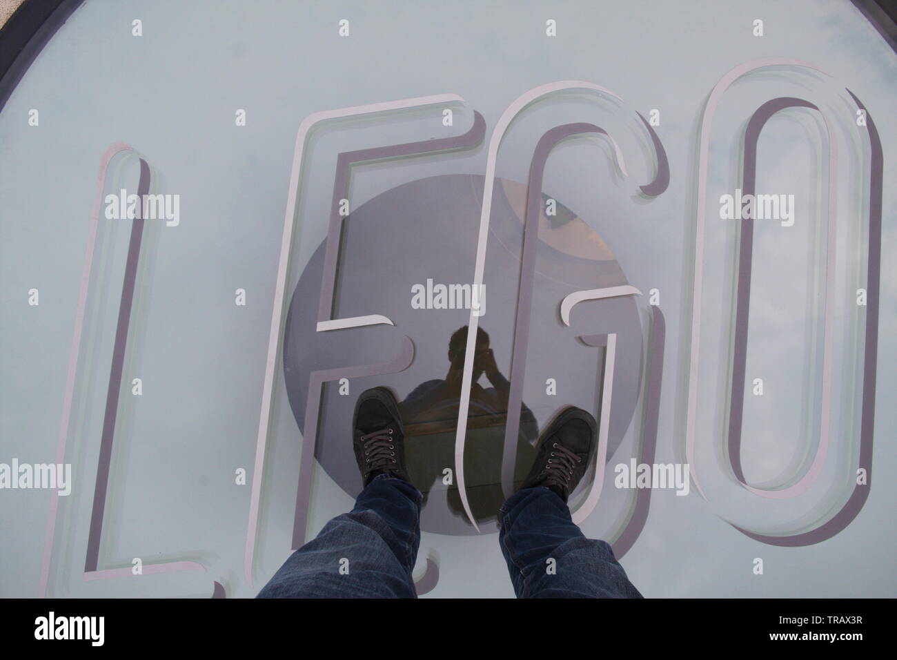 Debout les pieds sur la vitre logo Lego sur le toit de la maison de Lego, BILLUND, Danemark Banque D'Images